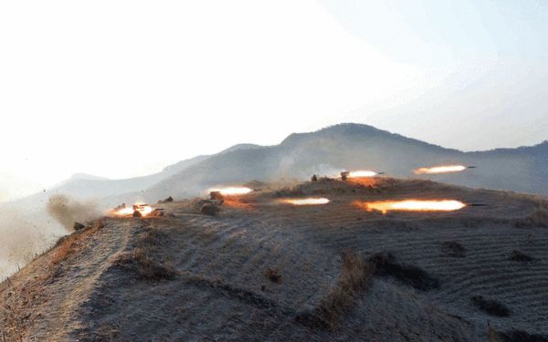 原文配圖：朝軍大演習山頂上火箭炮橫飛。